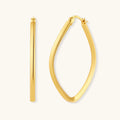 Set of geometric gold-plated sterling silver hoop earrings in oval and cushion shapes on cream background