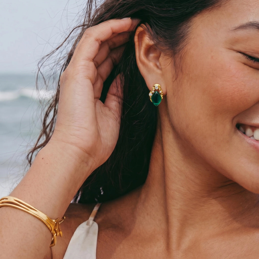 Gold stud earrings with emerald-cut green stone